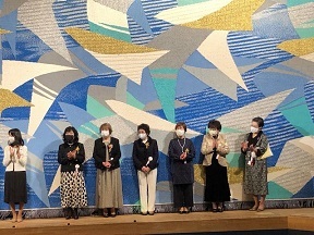 写真：女性会の皆さんが壇上で挨拶をしているところ