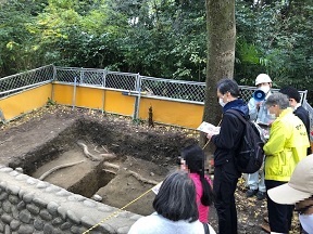 写真：発掘現場で参加者が説明を受けているところ