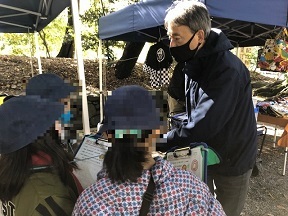 写真：ハチミツづくりの話を聞く児童たち