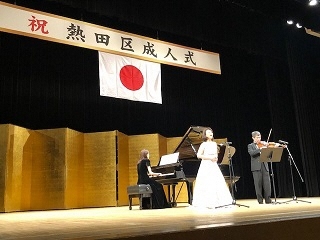 写真：舞台で歌と演奏を披露しているところ