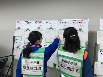 写真：避難所の一覧に派遣職員などの情報を記載しているところ