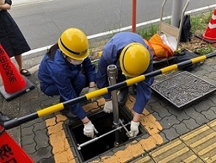 写真：応急給水施設で地下のセットをする職員