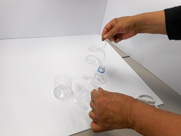 カットしたペットボトルを見せている写真