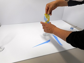 カットしたクリアファイルをグラスに入れている写真