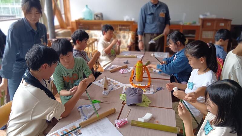 子どもたちがクラフトで竹水鉄砲を作成する様子です。