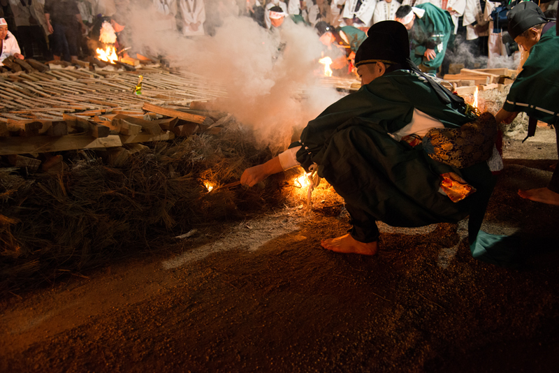 写真：火渡りの会場に火を灯す様子
