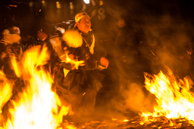 写真：火渡りをする参加者（火に向かってゆく様子）
