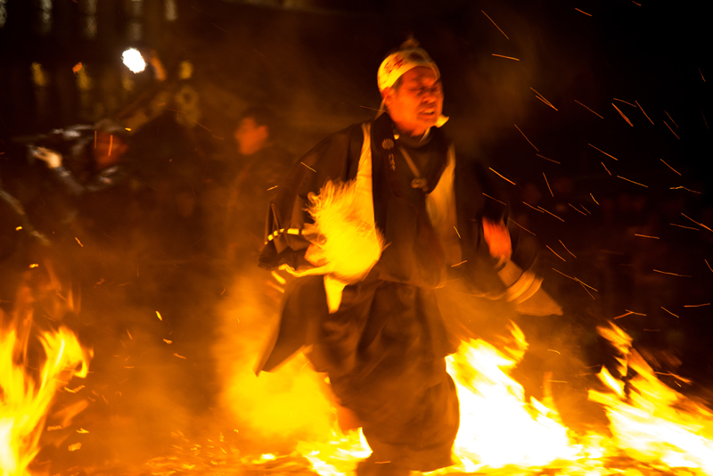 写真：火渡りをする参加者（火の中を渡る様子）