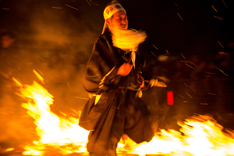 写真：火渡りをする参加者（勢いよく火を渡る様子）