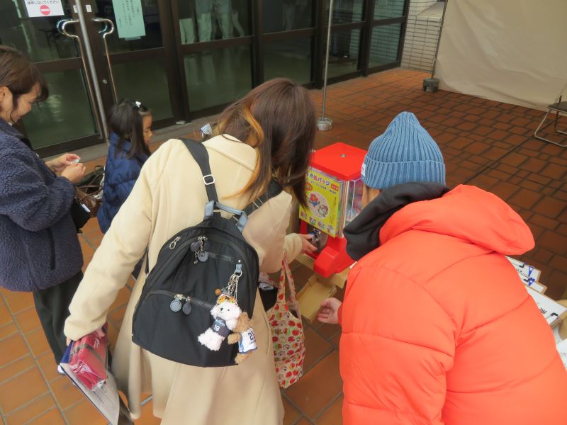 写真：缶バッジをガチャガチャで配布している様子