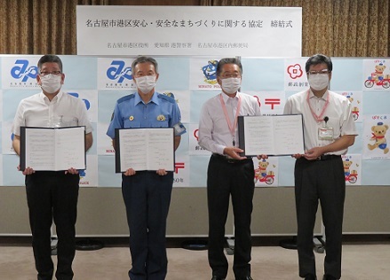 写真:署名後の協定書を持つ締結式の参加者