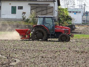 写真:おこした田に肥料を播くトラクター