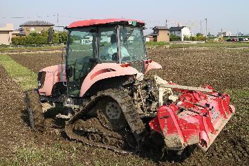 写真:田おこしをするトラクター