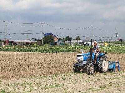 写真:畑を耕すトラクター