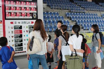 写真：選手の紹介や順位表、試合スケジュールが掲載されているのボードの説明を受けている様子2