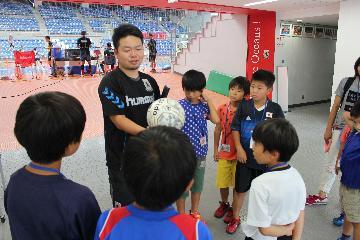 写真：練習中の選手から説明を受けている様子