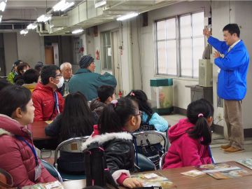 写真：金シャチけいばNagoya職員から競馬場の説明を受ける参加者