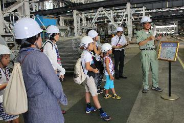 写真：整備員さんから列車集塵装置についての説明を聞く様子