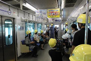 写真：点検中の車両内部で質問を受ける整備員さんの様子