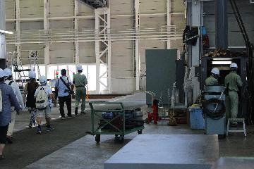 写真：整備員さんが働いている横を見学の列が通過して行く様子