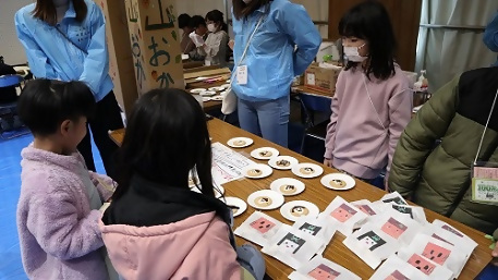 写真:こどものまちで買い物をする参加者の様子