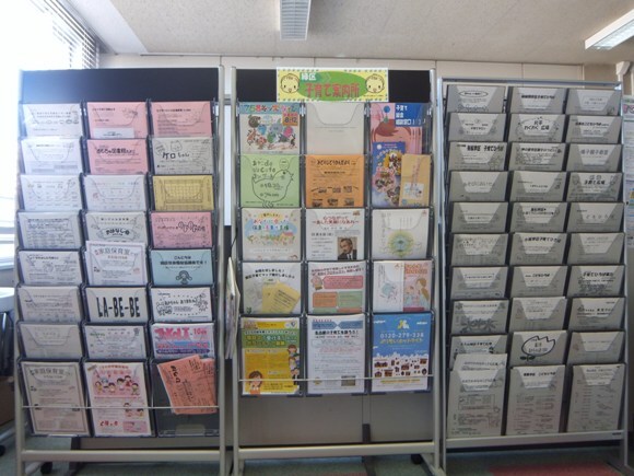 写真：縦に6種類から10種類のチラシが収納でき、横に3列あるラックが3つ並んでいます。