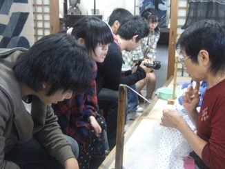 写真:絞りの実演を見て技術に感心する高校生