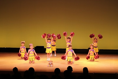 写真：8人の子どもたちがチアダンスを踊る様子