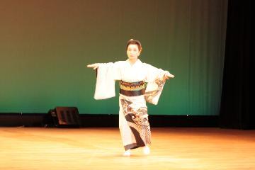 写真:白色の着物の女性が舞踊を踊る様子