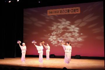 写真:桜色の着物の女性4人が民踊を踊る様子