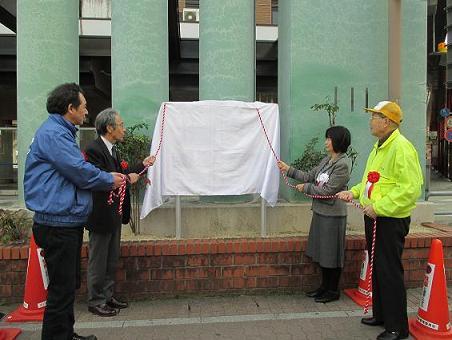 写真：除幕式で幕を引く前の様子