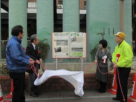 写真：除幕式で幕を引いている様子