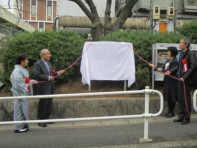 写真：除幕式で幕を引く前の様子