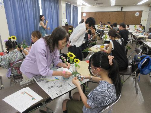 先生に教えてもらいながら参加者が花をいけている写真