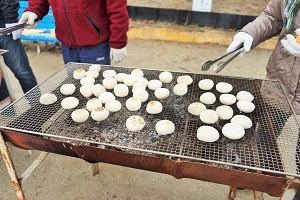 写真：丸餅が網で焼かれている様子