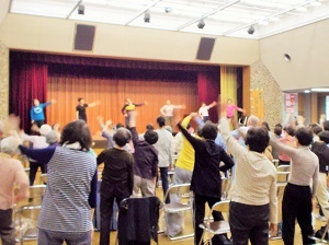 写真：区役所講堂で体を動かす参加者たち