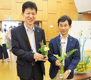 写真：区役所区民福祉部長と区長がそれぞれの作品を手にしている様子