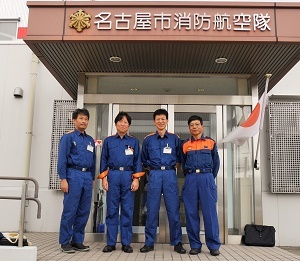 写真：名古屋市消防航空隊の建物入口前で記念撮影をする区長ら