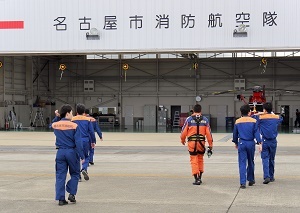 写真：ヘリコプターを降りて戻る区長らの後ろ姿