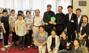 写真：アーティストを囲んで記念撮影をする区長とスタッフら