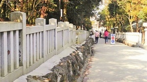 写真：神社の境内で、遠くに参加者が歩く風景
