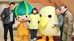 写真：スタッフとマスコットキャラクターとともに写真撮影をする区長