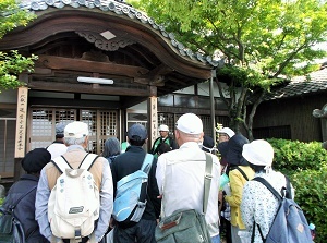 写真：善光寺の境内でボランティアスタッフの話に聞き入る参加者たちの様子