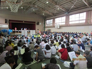 写真：体育館内で話を聞く参加者たちの様子