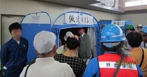 写真：組み立てられた仮設トイレの見学をする参加者たち