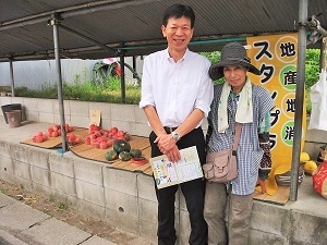 写真：浅井朝市のスタッフと記念撮影をする区長