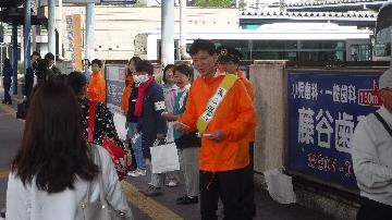 写真：オレンジリボン付きウェットティッシュを配布しているところ