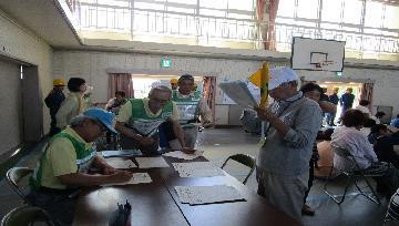 写真：受付設置訓練で、避難者登録票を作成しています