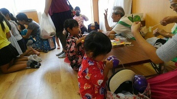 写真：子どもたちと高齢者たちが遊んでいる様子です