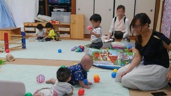 写真：赤ちゃんとお母さんが遊んでいる様子です